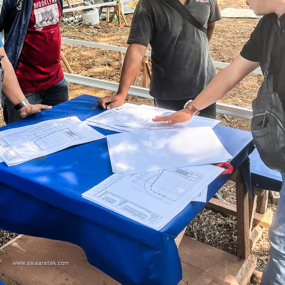 Tim arsitek meninjau langsung blueprint di lapangan konstruksi